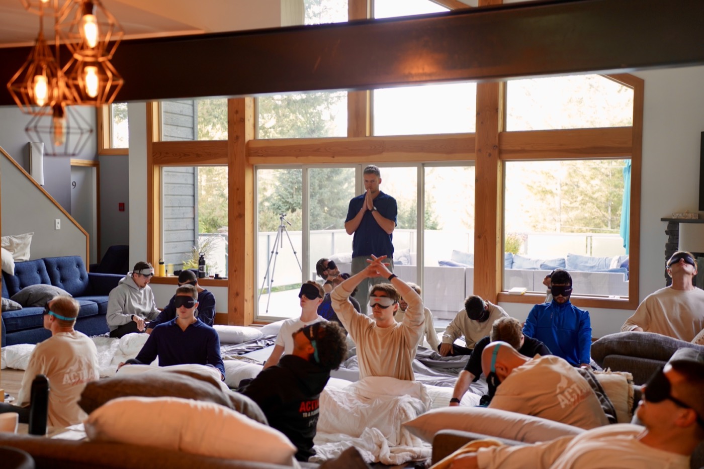 Benn holding space at the back of the room during a breathwork session at the Whistler retreat